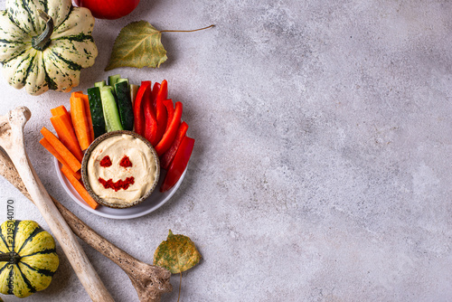 Fotografie Halloween hummus in jack-o-lantern shape with vegetables