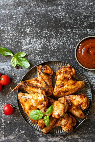 Barbecue chicken wings with sauce on a stone surface. Traditional baked bbq buffalo. Tasty snack for beer. Top view flat lay background. Copy space.