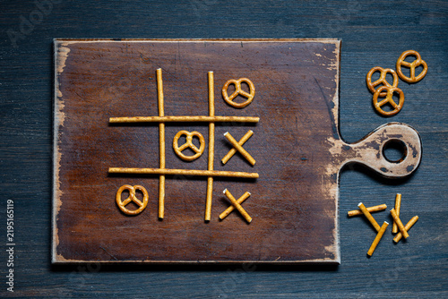 Картината върху платно Tic tac toe game made of pretzel sticks and twists top view, closeup
