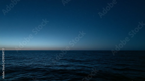 Flat, calm North Atlantic Ocean at night, with a blurred and indistinct horizon where the dark water merges seamlessly into the dark sky.