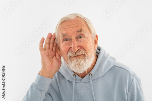 Fotografie Senior man cups hand behind ear trying to hear better, listening becoming harder with years, message read at first glance
