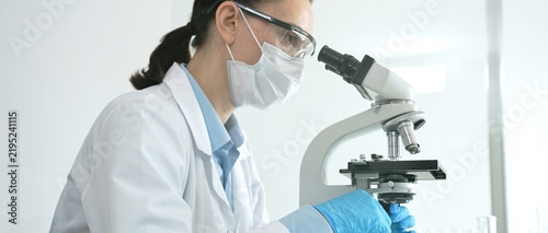 Canvastavla Dedicated female scientist working with a microscope in a modern laboratory, per