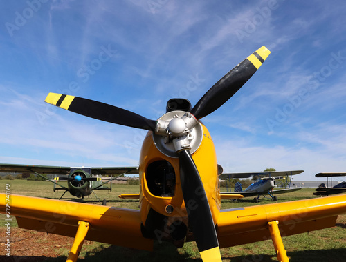 Fotografie Classic yellow propeller aircraft against a blue sky