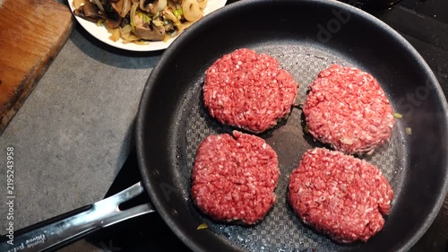 Stockholm, Sweden A cook in a residential kitchen fries homemade hamburger patties in a frying pan. 