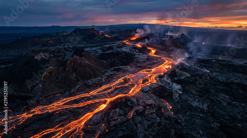 Aerial view of glowing lava rivers across volcanic terrain