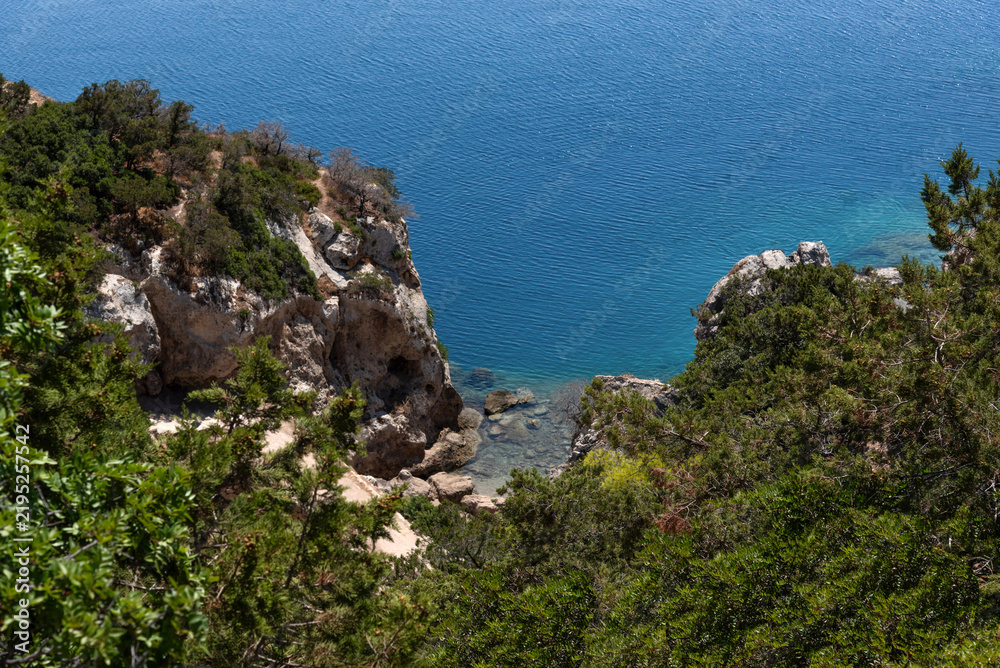Fototapeta premium Beautiful view from above of the blue sea and cliffs on a sunny day. The city of Loutraki, Greece. Mediterranean landscape.