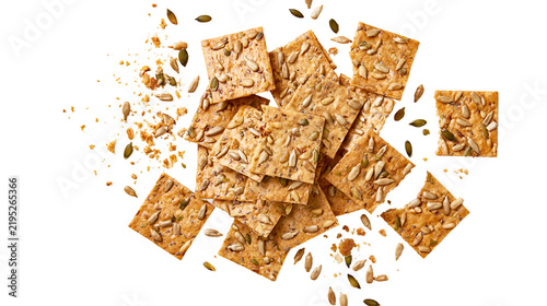 Foto Isolated healthy gourmet multigrain crackers with sunflower and pumpkin seeds scattered, crunchy snack