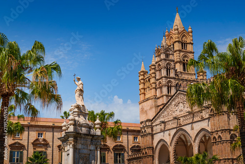 Palermo Cathedral Gothic bell tower with saint statue and palm trees, Sicily