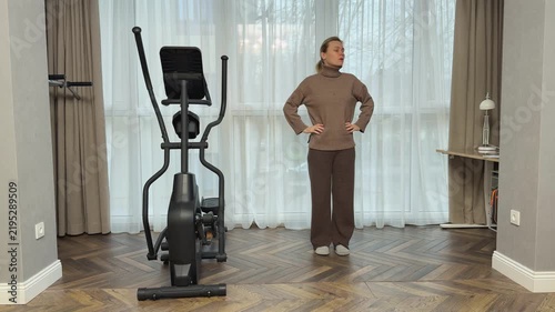 Woman in sports top, leggings and sneakers runs in place at high speed in living room. Intense home cardio training.