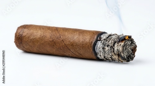 Burning Cigar With Wisps Of Smoke Against White Background Studio Shot