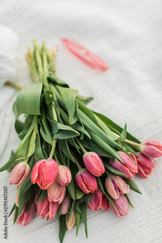 beautiful pink bright tulips on a beige blanket with pink sunglasses