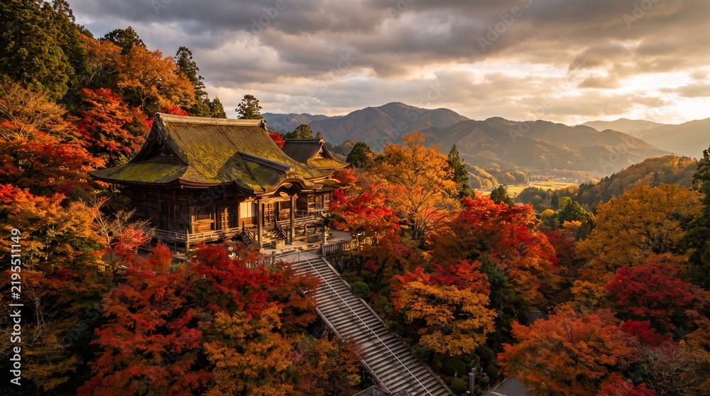 Obraz premium Scenic Autumn View of a Traditional Japanese Temple Surrounded by Colorful Maple Trees and Mist Covered Mountains at Golden Hour