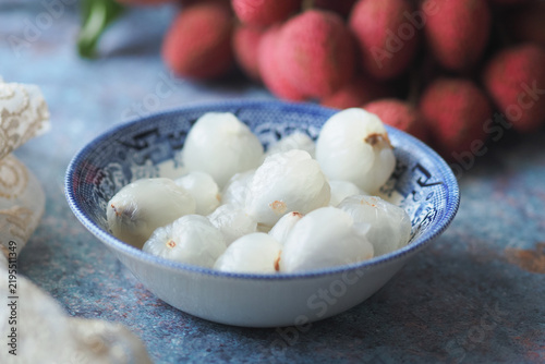 Canvastavla Bowl of lychee fruit on a table with additional lychee in the background