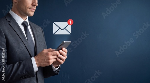 Professional Businessman in Elegant Suit Using Smartphone with Email Notification Icon for Mobile Communication and Online Messaging Services, Corporate Business Concept with Copy Space