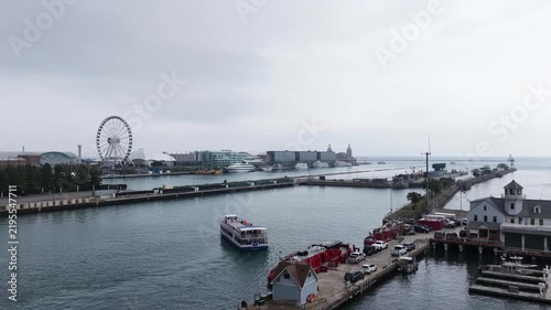  Aerial View of Navy Pier with Ferris Wheel and Tour Boat, Chicago” An aerial view of Navy Pier in Chicago, featuring its iconic Ferris wheel, tour boat cruising along the harbor, and pier buildings 