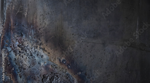 Burned industrial iron plate surface textured with heavy welding slag and oxidized patina