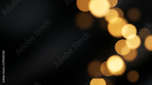 Golden bokeh lights on dark background. Festive glow backdrop