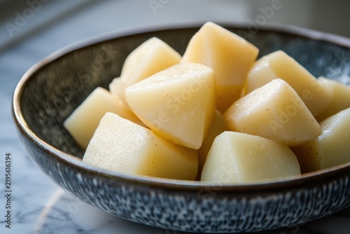 Close-up view of cooked, cubed potatoes in a bowl.