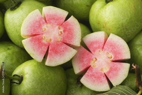 Many fresh pink guava fruits close up
