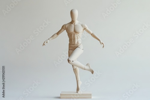 Wooden mannequin in a dynamic, leaping pose.