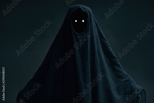 Eerie shadow monster costume with glowing eyes for a spooky Halloween celebration and dark theme