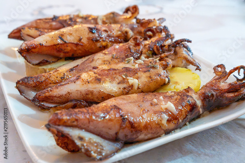 Grilled squid topped with garlic and herbs, presenting a delicious and healthy mediterranean seafood meal, High-Protein and Low-Mercury Seafood