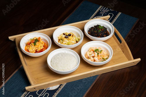 Chinese Home-style Set Meal on Wooden Tray. Five Small Dishes with Rice Close-up
