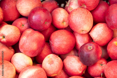 Pile of ripe red apples fills the frame at a fruit stand
