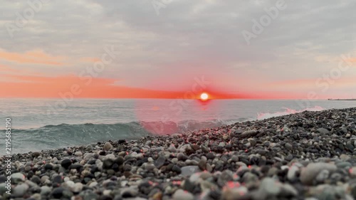 Timelapse Calm waves at sunset. Wave splashing over pebbles at sea with foam. Rolling ocean waves. Summer paradise beach background at sunset timelapse. 