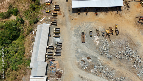 Aerial perspective of heavy trucks and industrial mining machinery parked at a remote work site