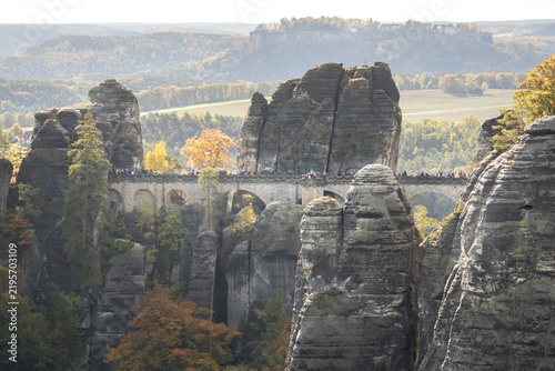 Konstfotografi Famous Bastei Bridge crossing towering sandstone cliffs in Saxon Switzerland, Germany, with autumn foliage, forested hills and a dramatic landscape
