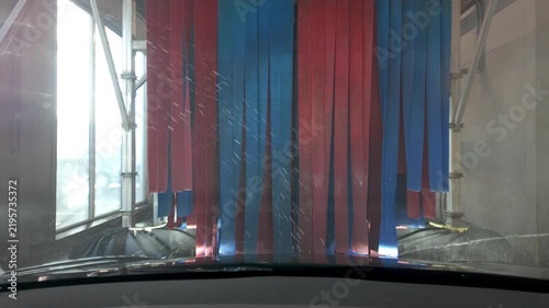 POV Footage of a Vehicle in an Automated Car Wash with Water and Foam on the Windscreen