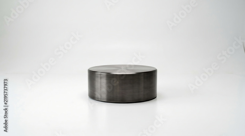 Minimalist Brushed Metal Cylinder Display Stand for Product Photography in a Bright Empty Studio White Space