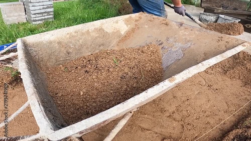 Sand Shoveled Into a Metal Wheelbarrow Outdoors