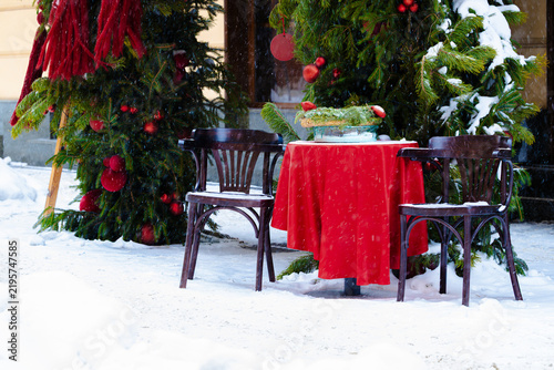 funny decorative dinner place outside on a street in winter snow wall time Christmas eve season with festive interior and exterior objects