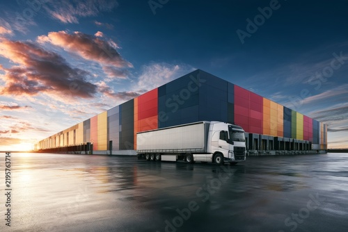 Large warehouse with truck parked during sunset