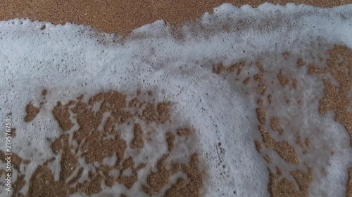 Heart drawn in the sand is washed away by the sea waves