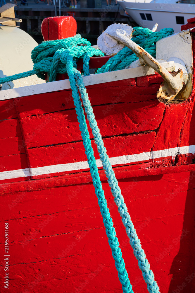 Fototapeta premium Close-up of a red wooden fishing boat docked in the harbor.