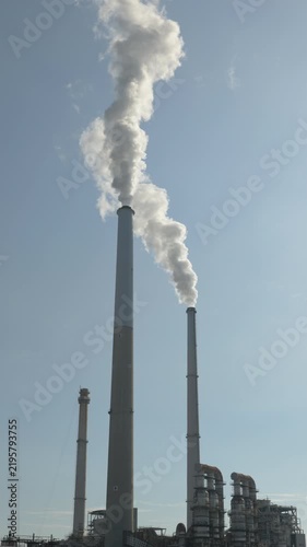 Industrial Plant Chimneys Emitting Smoke Over Water (Vertical | Real Time | ZOOM IN)
