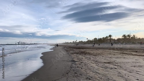 People on a sunny winter day actively relax with their families. A day off on the beach of the Mediterranean Sea in winter. Grao. Castellon de la Plana. Valencia. Spain