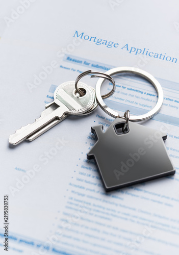 Mortgage application form with house keys representing home ownership