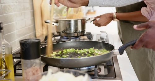 Lifestyle videos indoor of people doing activities at home, cooking vegetables in frying pan, person