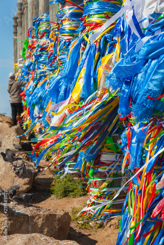 Lake Baikal. Sacred place on Olkhon Island, near Khuzhir. Tourists and Buddhists come to Cape Burkhan to tie colorful ribbons, Hadaks, and Buddhist prayer flags with mantras to the 13 Serge pillars