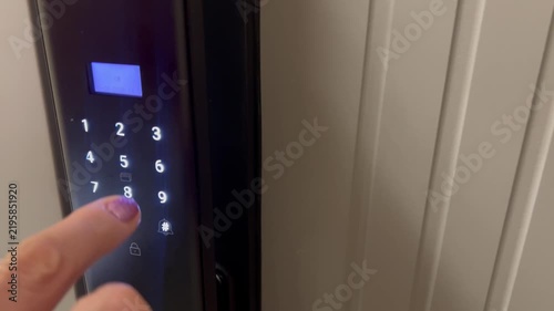 Close-up of a person pressing digits on an electronic keypad door lock, smart home security access control system with illuminated touchscreen panel in 4K.