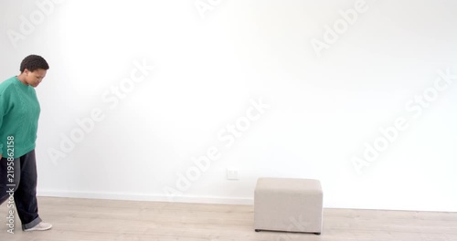 Person in green sweater standing indoors, looking forward with calm expression