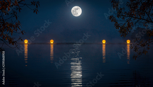 Full moon reflected on calm water with warm lanterns and autumn branches, meditative atmosphere for Mid-Autumn Festival