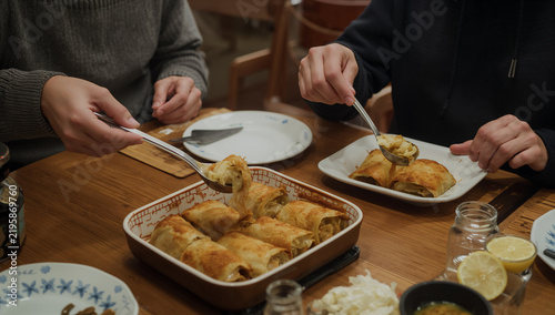 Naklejka 食卓でロールキャベツを取り分ける大人二人