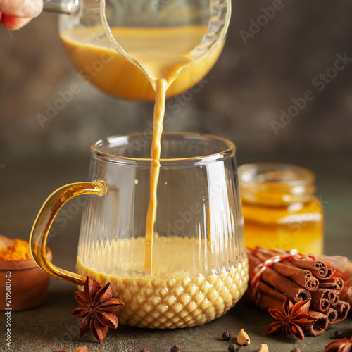 Golden Cinnamon  Turmeric Milk. Trendy hot Healthy drink with turmeric roots and spices. Indian Masala Haldi Doodh.