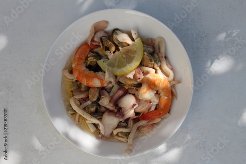 A seafood cocktail with shrimp, mussels and squid on a lemon plate is beautifully served for lunch.