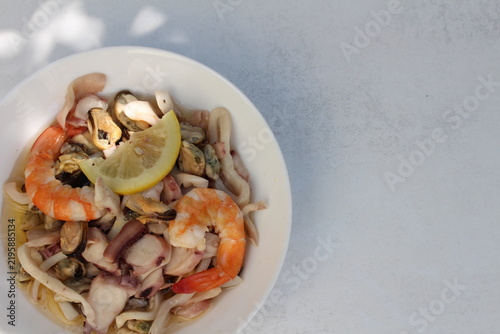 A seafood cocktail with shrimp, mussels and squid on a lemon plate is beautifully served for lunch.